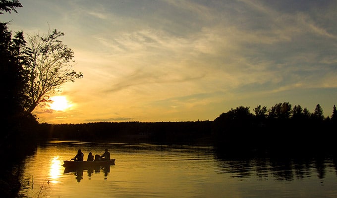 Wissenswertes-über-Kanada Familie im Kanu genießt Abendstimmung Fluß Cape Breton